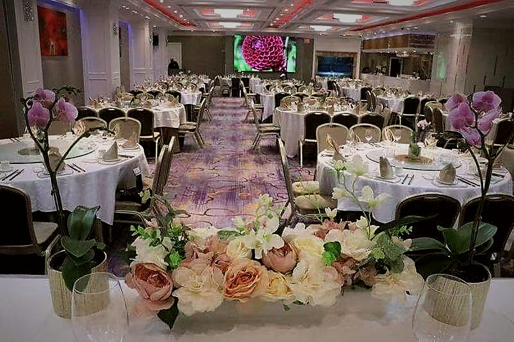 A banquet set-up in the main hall with flowers on every table